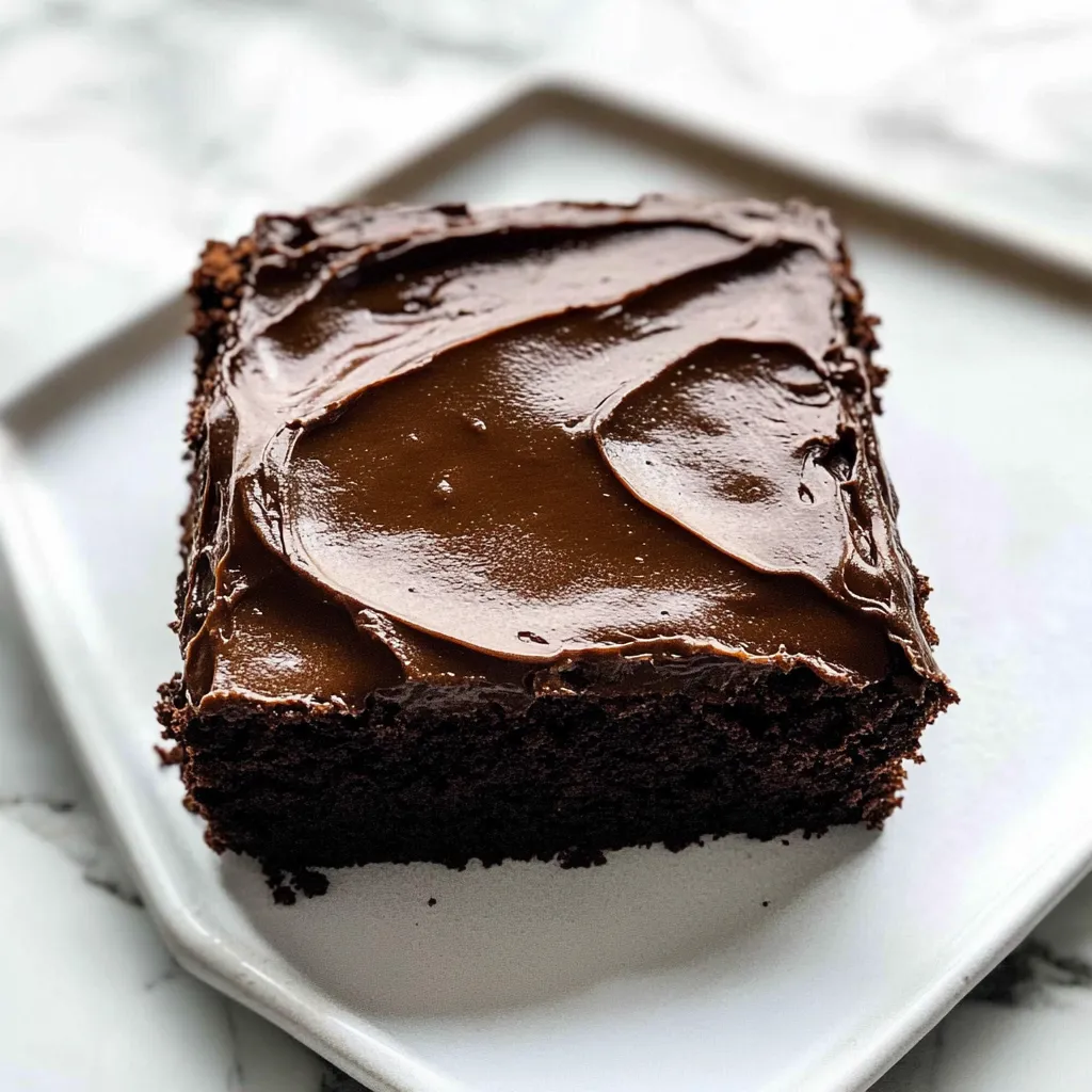 A square piece of chocolate cake with a drizzle of chocolate sauce on top.