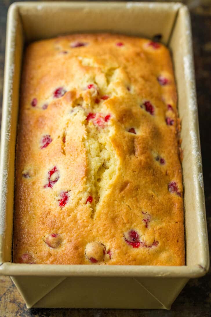 A loaf of bread with red berries on top.