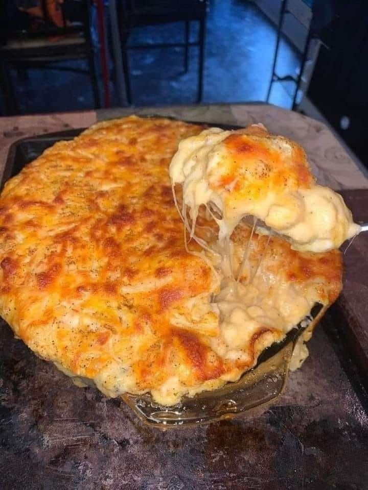 A cheesy casserole with a fork in it.