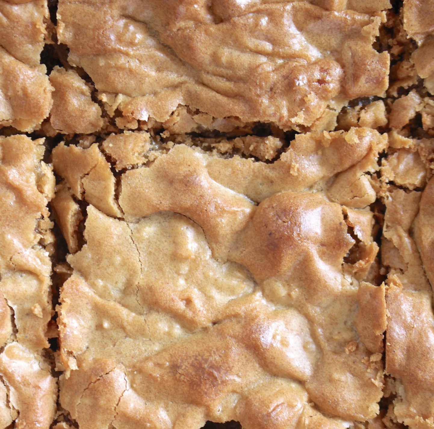 A square of brownies with a bite taken out of it.