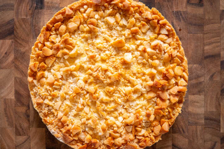 A slice of pizza with cheese and nuts.