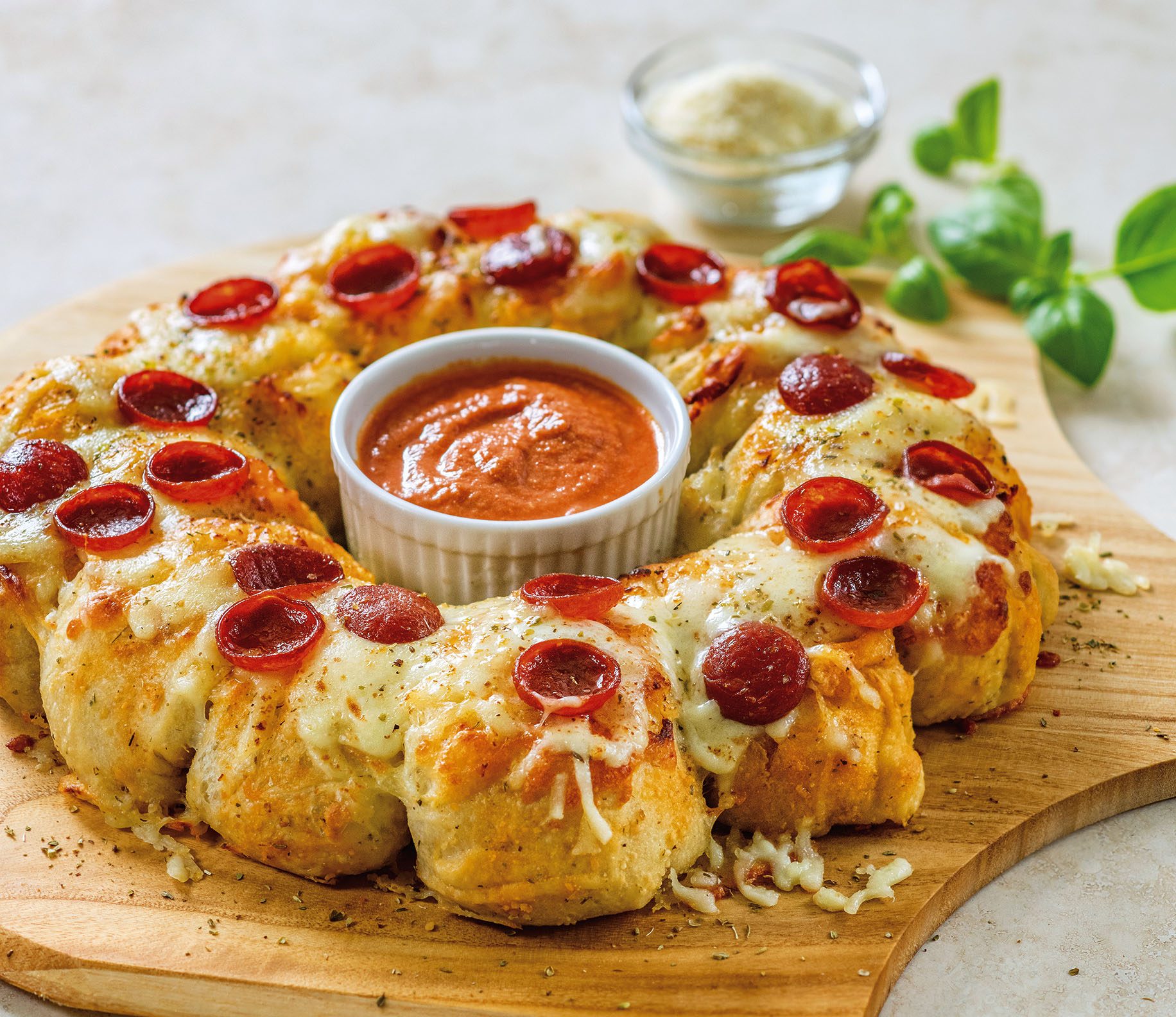 A pizza with pepperoni and cheese on a wooden board.