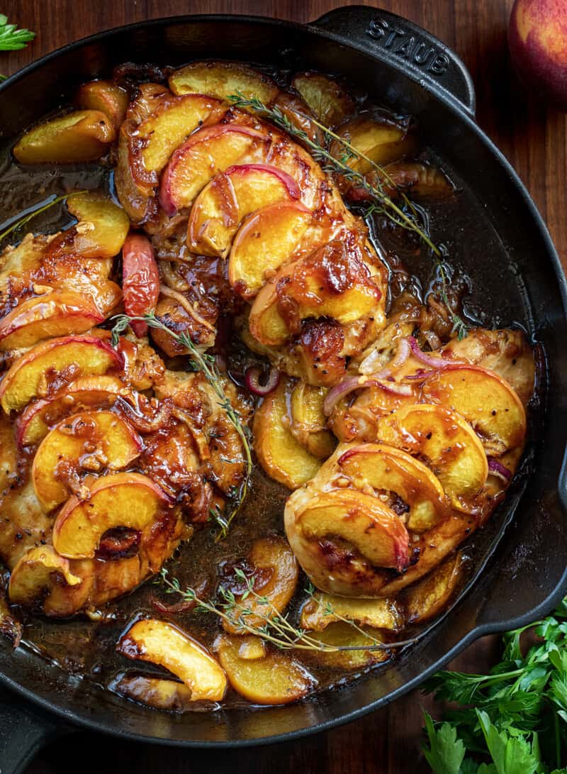 A pan of chicken with apples and onions.
