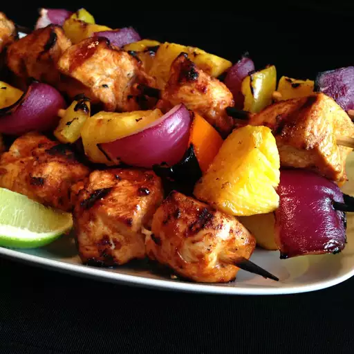 A plate of food with a lime wedge and a skewer of meat.