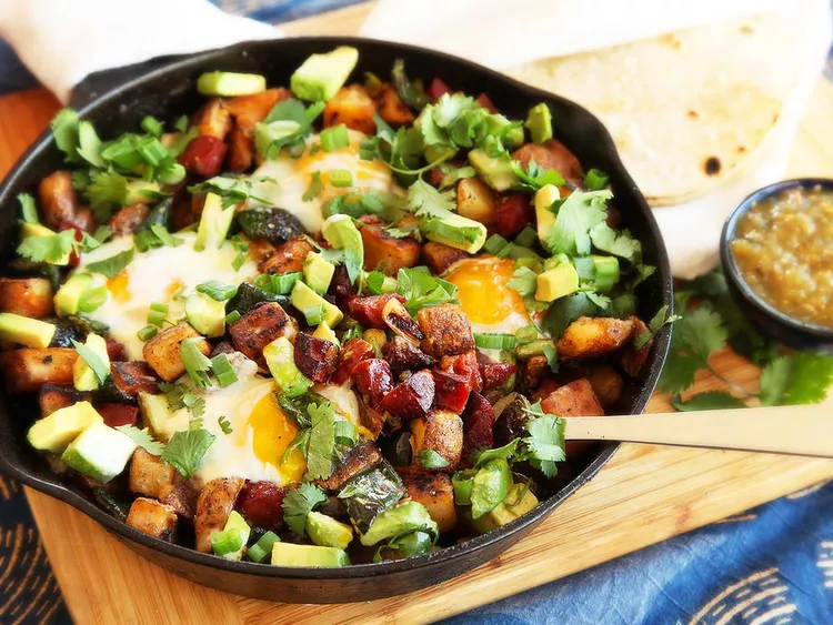A fried egg in a skillet with vegetables.