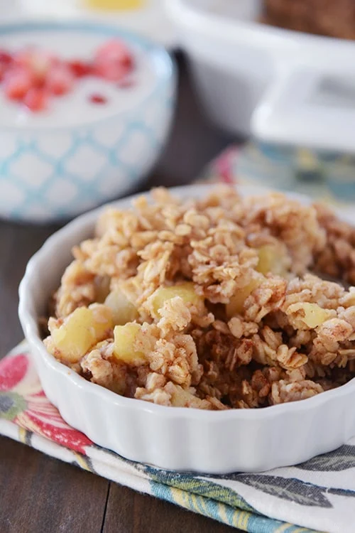 A bowl of cereal with fruit on top.