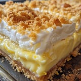 A slice of pie with whipped cream on top.